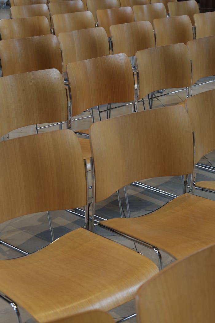Rows of wooden chairs arranged neatly indoors in Manchester, UK.